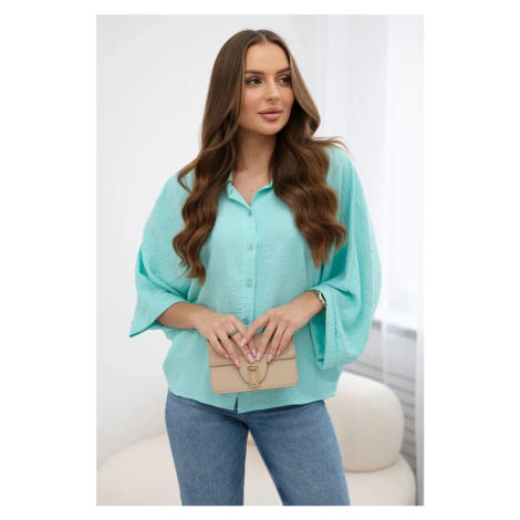 Mint-colored oversized blouse with button closure