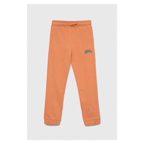 Detské bavlnené tepláky Guess oranžová farba, jednofarebné